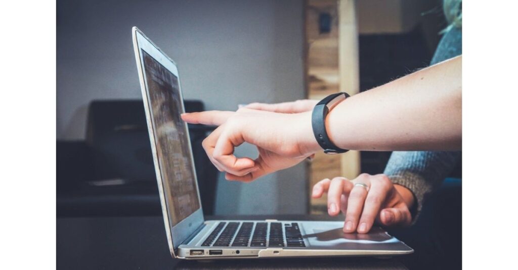 Person pointing at a computer screen