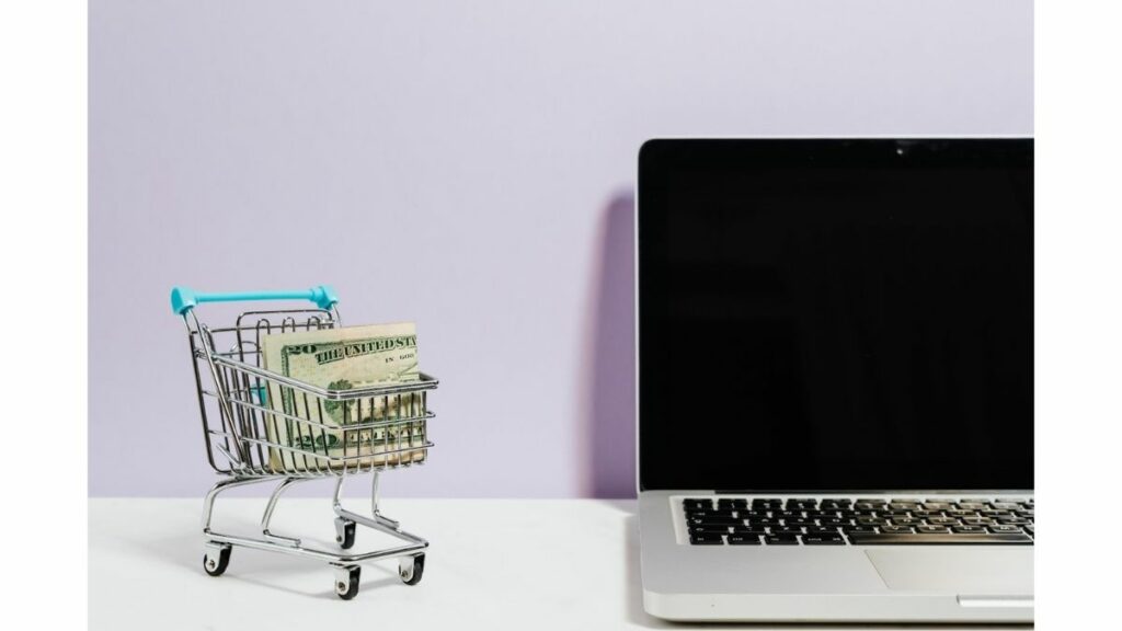 a cart full of money next to a computer