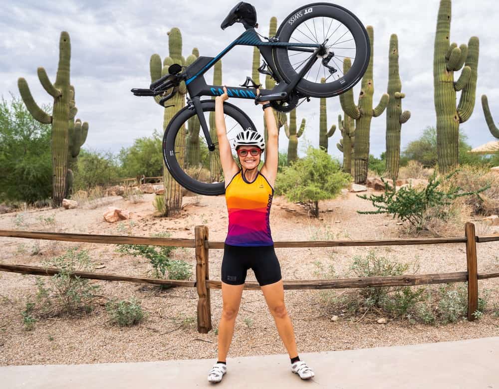Christy holding her bike over her head