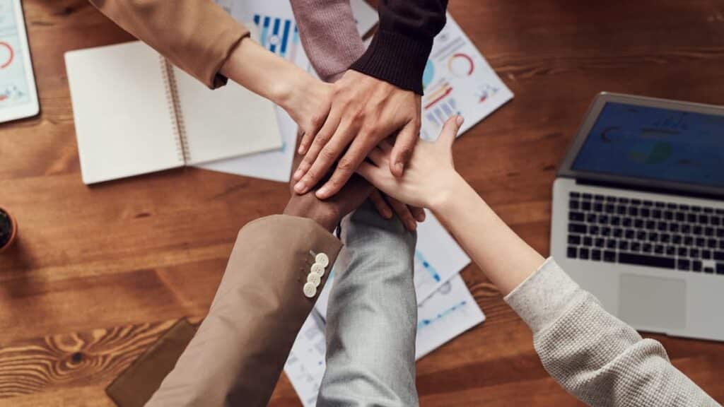 group of marketers touching hands