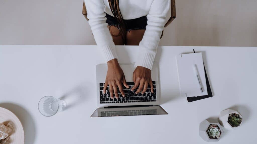 a person sitting at a table typing with lunch
