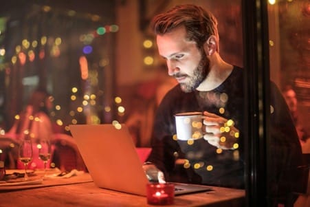 man clicking serps drinking coffee
